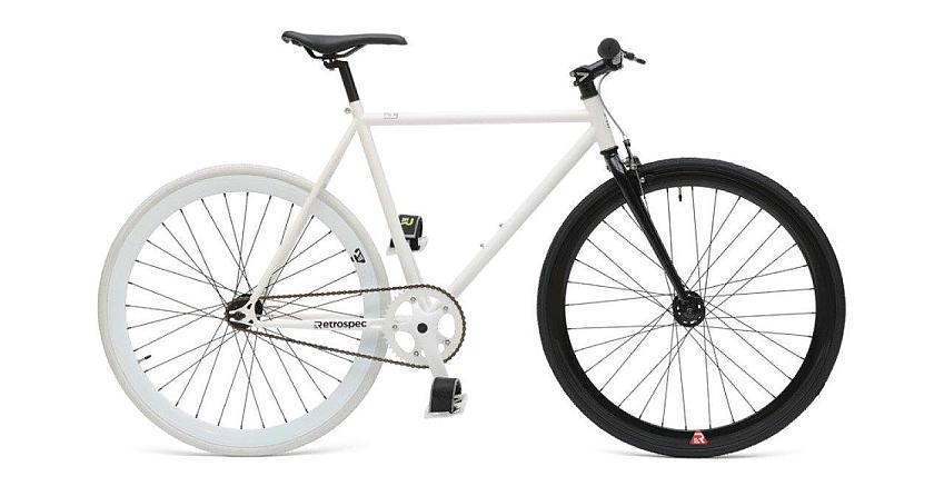The Retrospec Mantra Fixed/Singlespeed bike in white, with one white wheel and one black wheel