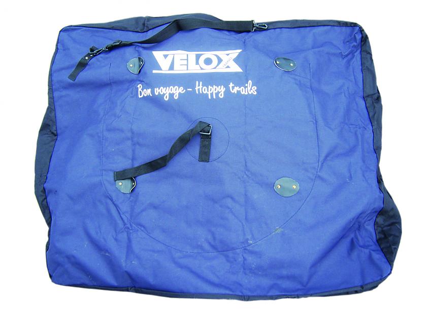 Velox's bike bag. It's unpadded and material rather than plastic. It's blue and black and has the words Bon Voyage – Happy Trails printed on it