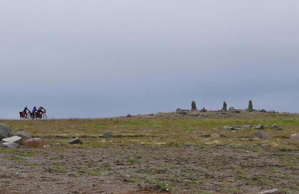 Cyclists riding past standing stones in Iceland