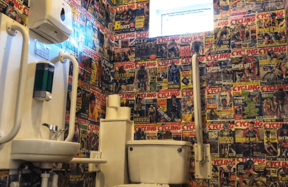 A toilet in a cafe the walls of which have been decorated with magazine pictures 