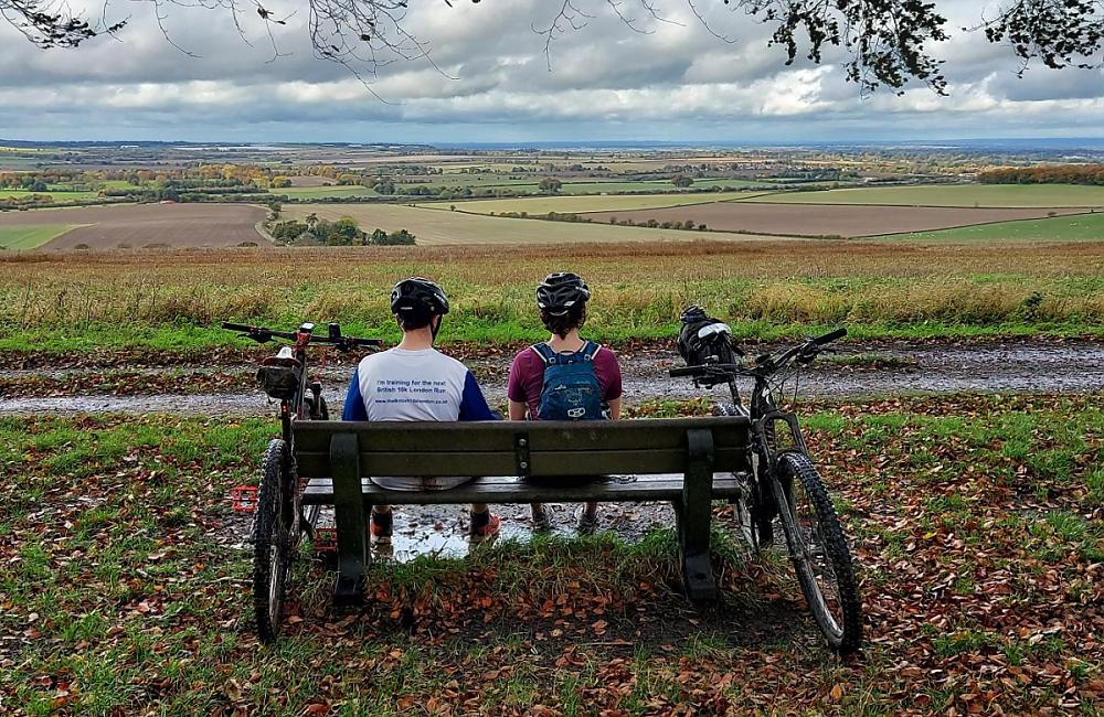 Two cyclist look out from King Alfreds Way sat on a bench
