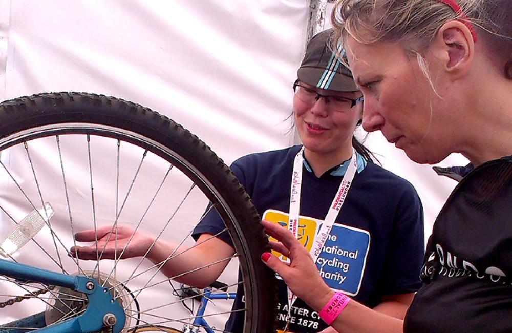 A Dr Bike volunteer fixing a participant's cycle