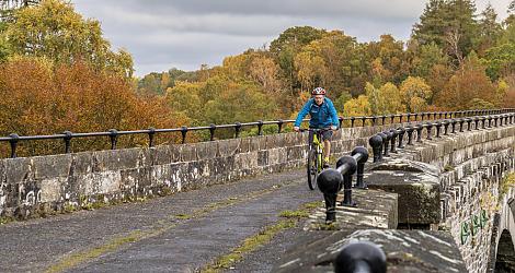 A man cycles along a disused railway viaduct