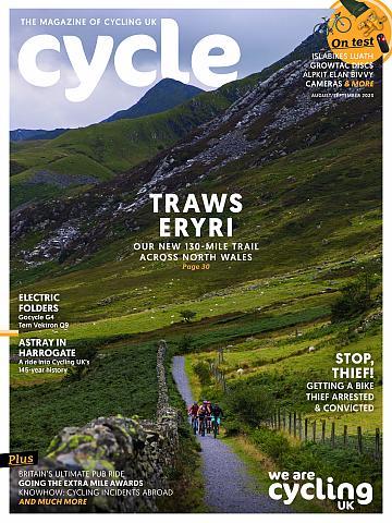 The front cover of Cycle magazine's August/September 23 issue featuring a group of people cycling on a gravel path through Welsh mountains